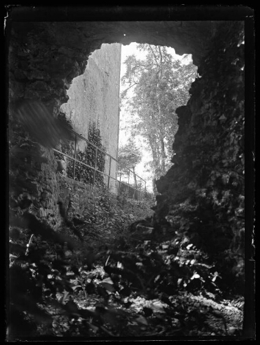 Essai (Orne) : aperçu du château d'Essay à travers la brèche dans le rempart sur l’élévation latérale de la chapelle et les caves du logis