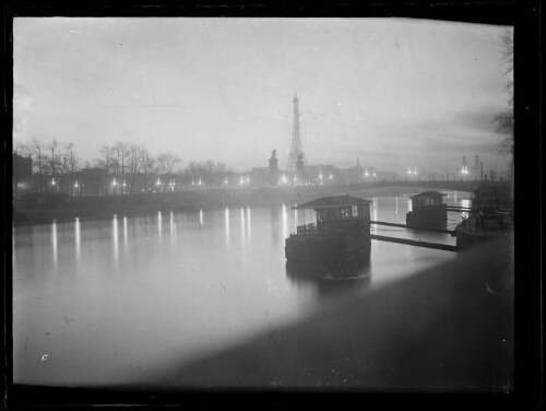 Paris : deux péniches sur la Seine à la tombée du jour ; pont Alexandre III et Tour Eiffel en arrière-plan