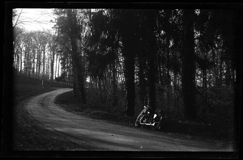 Paysage forestier : moto stationnée au bord d'une route de forêt