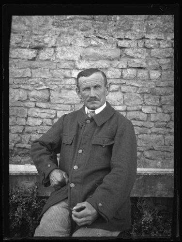 Portrait en buste d'un homme âgé assis dehors sur une chaise