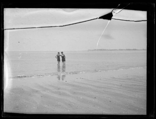 La Baule (Loire-Atlantique) ? : deux hommes, les pieds dans l'eau regardent vers la plage, bras dessus bras dessous