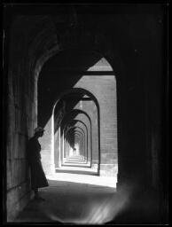 Arcades d'un monument avec une femme debout sous les arcades