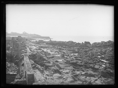 Paysage côtier : sol rocheux en bord de mer ; côte et mer en arrière-plan