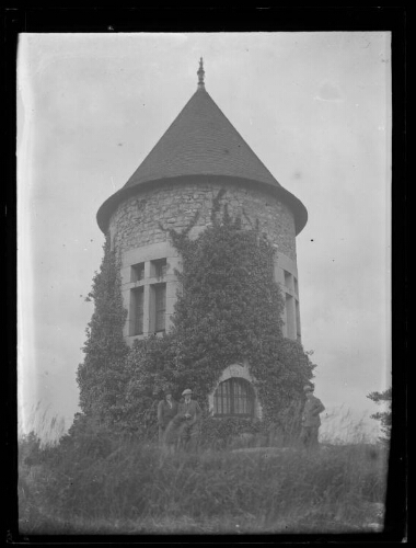 Boitron (Orne) : un couple et un homme debout au pied de la « Tour ronde » située au sommet de la butte où était le château des Talvas (anciens seigneurs de Bellême)