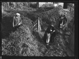 Gustave et Augustine Chevalier, les grands-parents de Marc Bry, et un couple s'embrassent sur le chemin menant à une maison, un homme les regarde