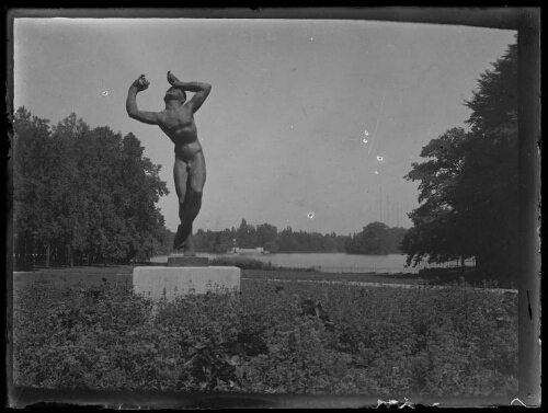 Paysage : statue d'un homme nu, bras levés, jambes croisées dans un parc ? ; plan d'eau en arrière-plan