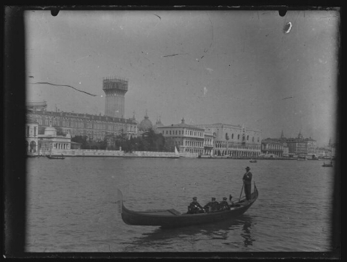 Venise (Italie) : gondole sur le grand canal de Venise avec trois hommes en uniforme et le gondolier ; vue panoramique sur la place Saint-Marc et ses alentours en arrière-plan