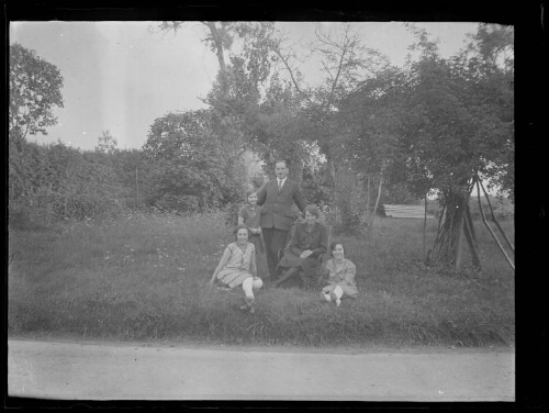 Portrait de groupe : un couple et trois jeunes filles posent dans un parc