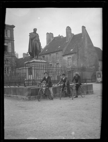 Sées (Orne) : statue de Conté devant la mairie de Sées ; trois hommes à vélo posent devant la statue