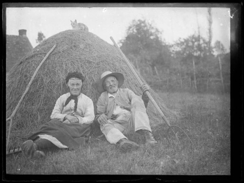 Gustave et Augustine Chevalier, les grands-parents de Marc Bry, assis au pied d'une meule de foin, au lieu-dit « Le Gué »  à Essay (Orne), le 6 juillet 1929