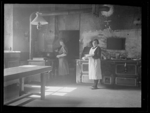 Scène d'intérieur : deux femmes dans une cuisine aux fourneaux