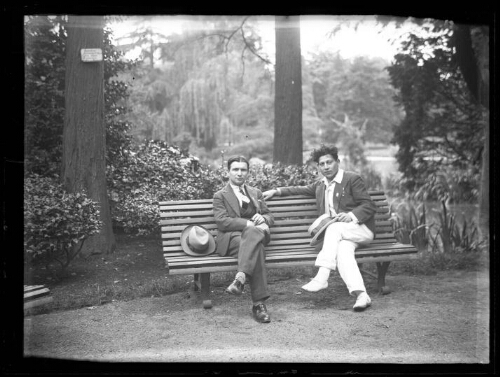 Marc Bry avec un amis assis sur un banc dans un parc arboré