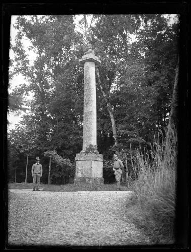 Marc Bry, en habit militaire, avec un ami au pied d'une statue au sommet d'une colonne